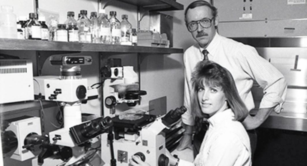 Two people using a microscope